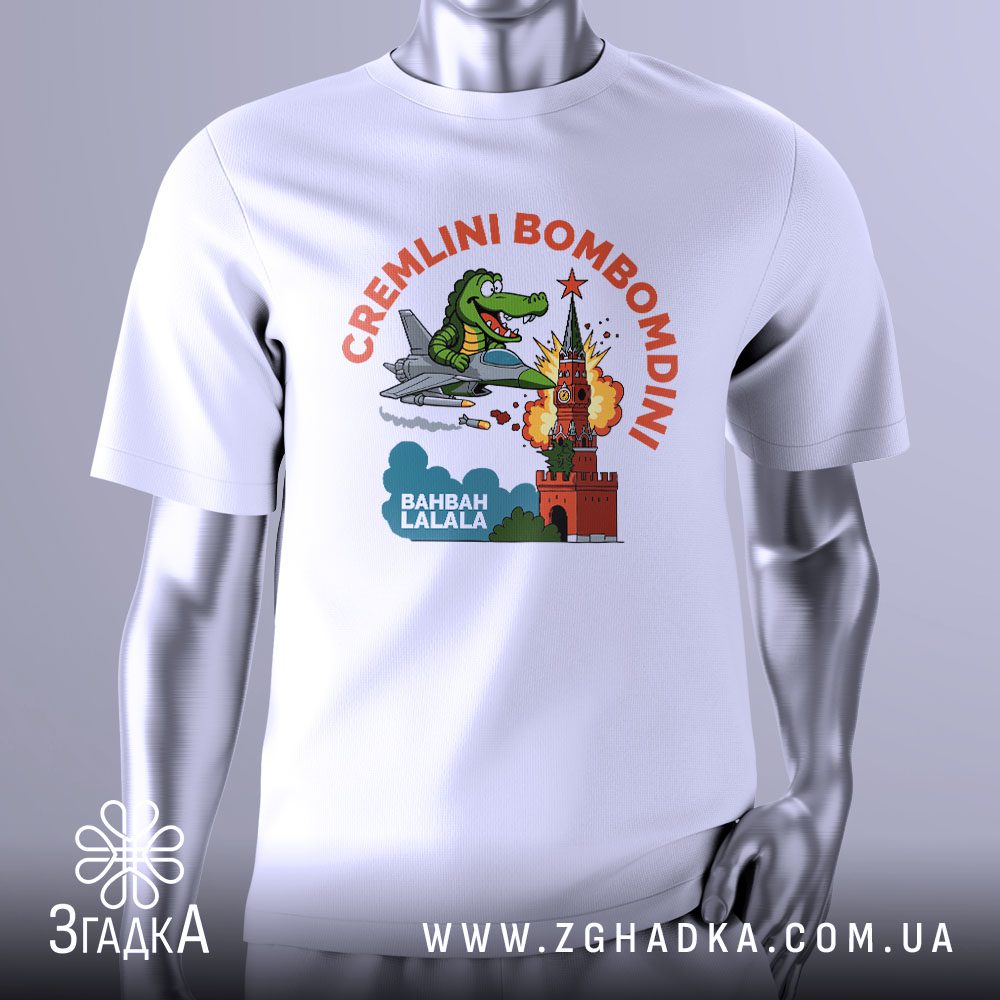 Футболка Cremlini Bombomdini Подарунок: Біла футболка з мультяшним крокодилом у літаку, що бомбить кремлівську вежу, та написом "CREMLINI BOMBOMDINI".
