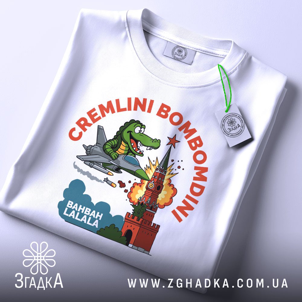 Футболка Cremlini Bombomdini Подарунок: Детальний план на принт крокодила, що летить у літаку та руйнує вежу.