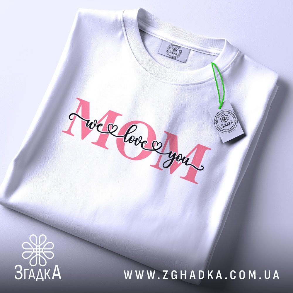 Футболка We Love Mom - крупний план слова "MOM" рожевого кольору.