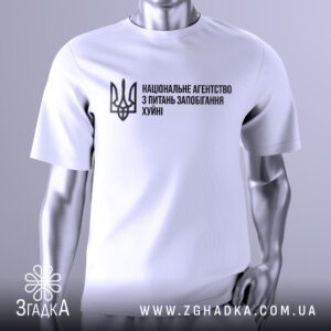 Біла футболка Агентство Запобігання Подарунок на сріблястому манекені, що демонструє принт з написом "НАЦІОНАЛЬНЕ АГЕНТСТВО З ПИТАНЬ ЗАПОБІГАННЯ ХУЙНІ" та українським гербом.
