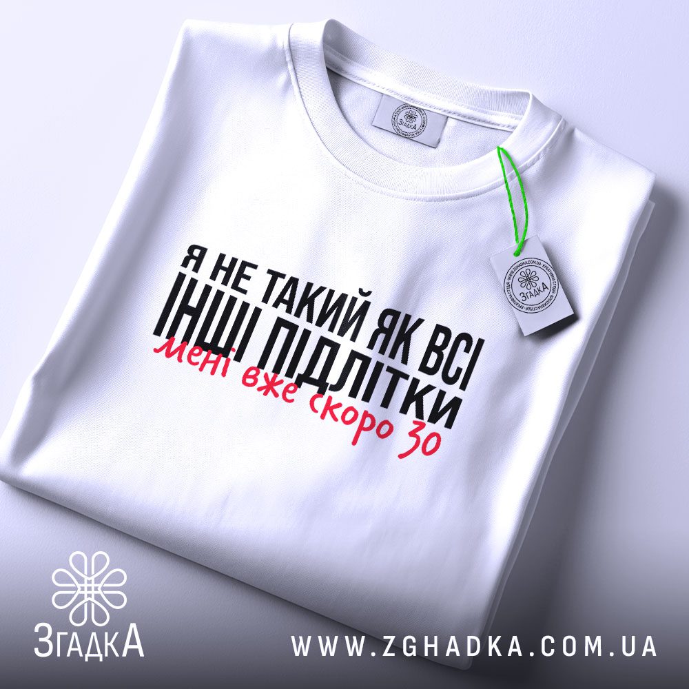Складена біла футболка Мені скоро 30 з актуальним гумористичним написом та етикеткою згадка.