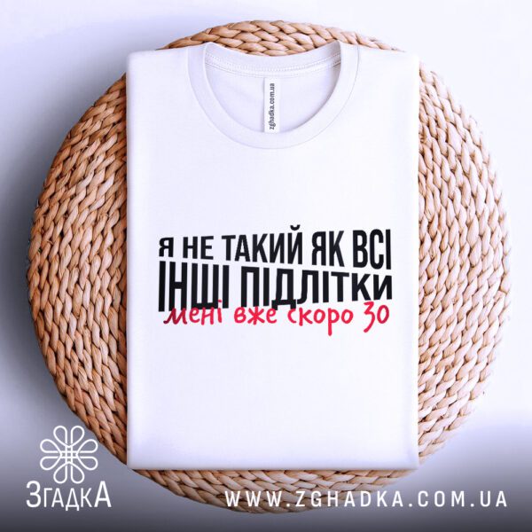 Фронтальний вигляд білої футболки Мені скоро 30 на манекені, крупний план принта.
