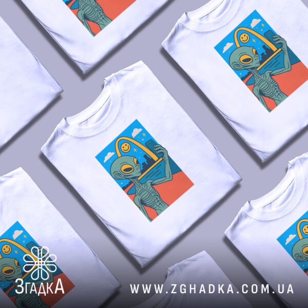 Креативна презентація складених білих футболок прибулець селфі з повторюваним принтом.