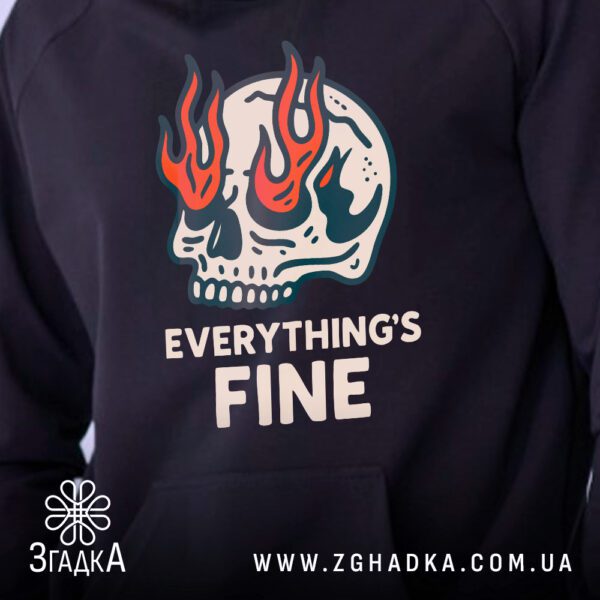 Крупний план палаючого черепа та напису Everything’s Fine на чорному тканинному фоні