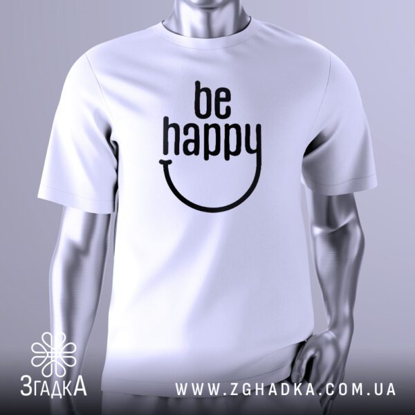 Біла футболка з великим чорним текстовим принтом у центрі. Напис "be happy" виконаний стилізованим шрифтом, де літери "e" та "y" у слові "happy" об'єднані, формуючи вигнуту лінію, що нагадує посмішку. Загалом, принт виглядає як веселе обличчя. Футболка на сірому манекені.
