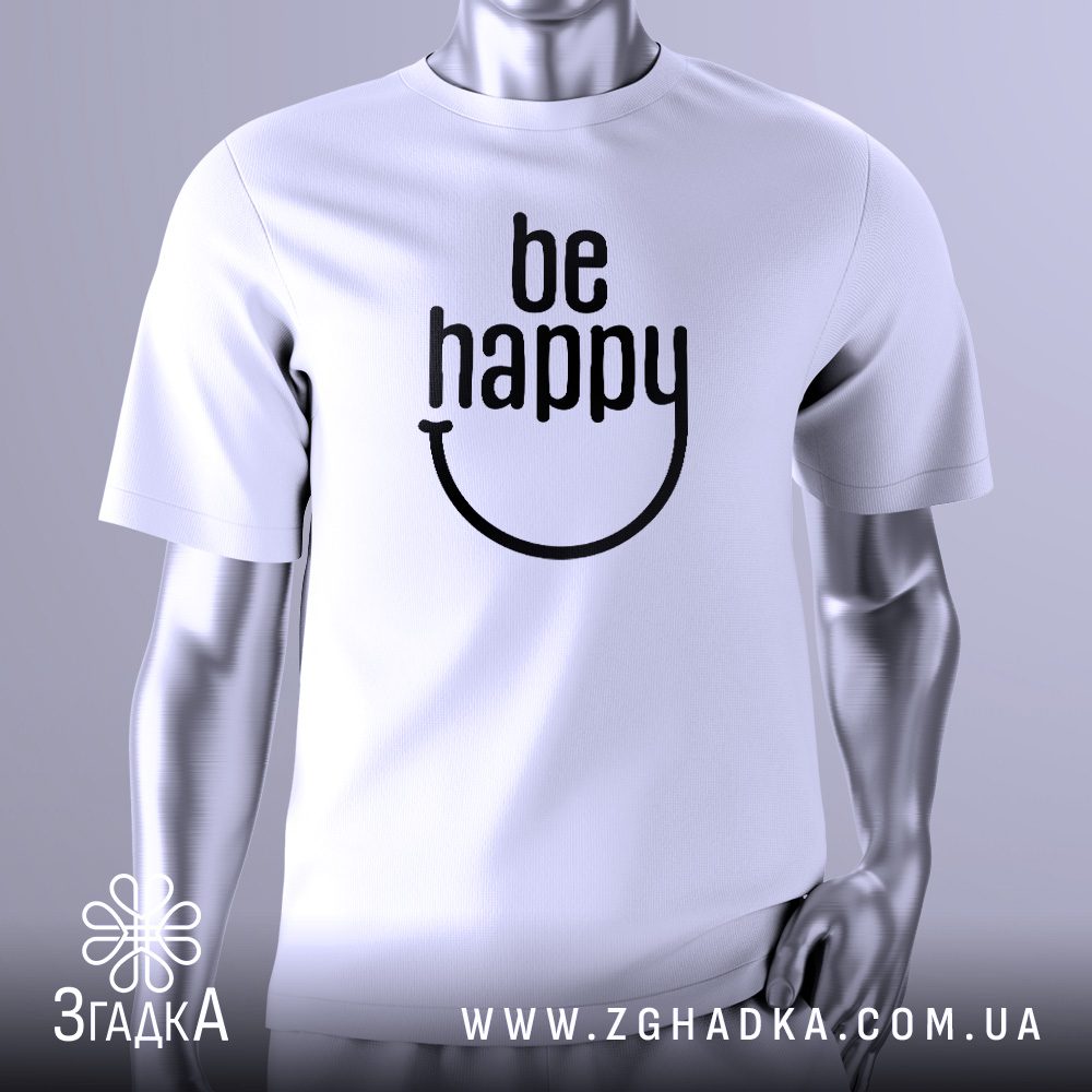 Біла футболка з великим чорним текстовим принтом у центрі. Напис "be happy" виконаний стилізованим шрифтом, де літери "e" та "y" у слові "happy" об'єднані, формуючи вигнуту лінію, що нагадує посмішку. Загалом, принт виглядає як веселе обличчя. Футболка на сірому манекені.