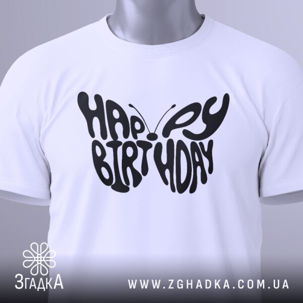 Крупний план принта метелика з "Happy Birthday" на білій футболці, що детально показує композицію з тексту.