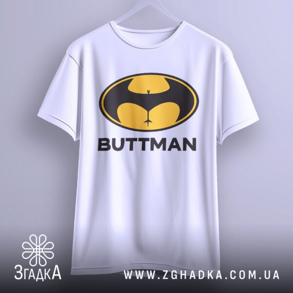 Чорна футболка з принтом "BUTTMAN" на білих плічках.