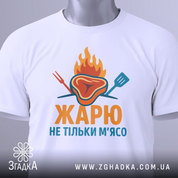 Крупний план графічного принта стейка на вогні з написом на білій футболці.