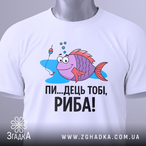 Крупний план кольорового принту веселої фіолетової риби з рожевими плавцями та великими очима, яка тримає вудку, а на гачку висить червоно-білий поплавок, та напису "ПИ...ДЕЦЬ ТОБІ, РИБА!" на білій футболці.