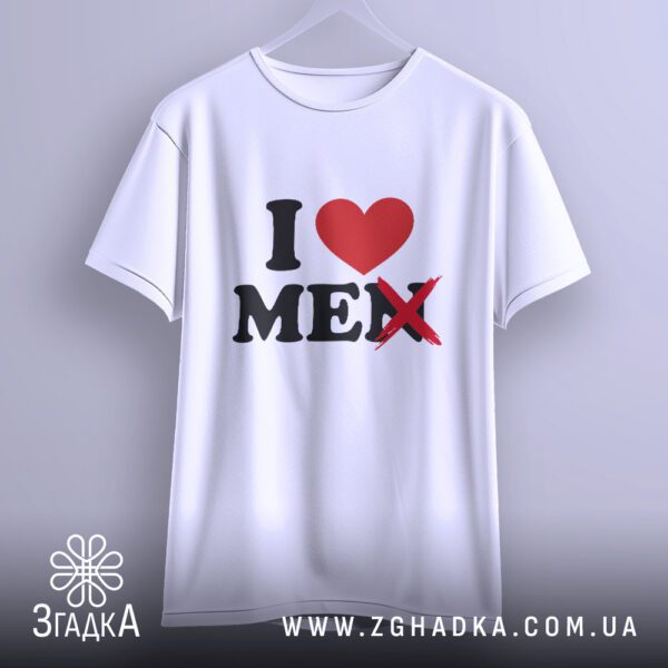 Біла футболка з принтом "I ❤️ MEN" (перекреслено), що висить на білих плічках, демонструючи дизайн.