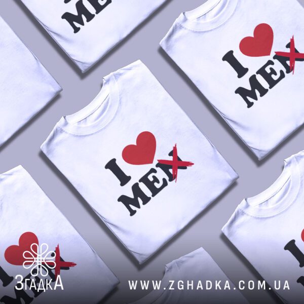 Кілька білих футболок з принтом "I ❤️ MEN" (перекреслено), складені стопкою або розкладені поруч на світлому фоні.