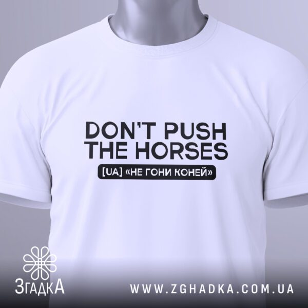 Крупний план принта "Don’t push the horses" на білій футболці, що детально показує текст та графічний елемент.
