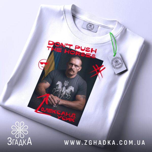 Складена біла футболка з принтом "don't push Усик" та етикеткою "Згадка".