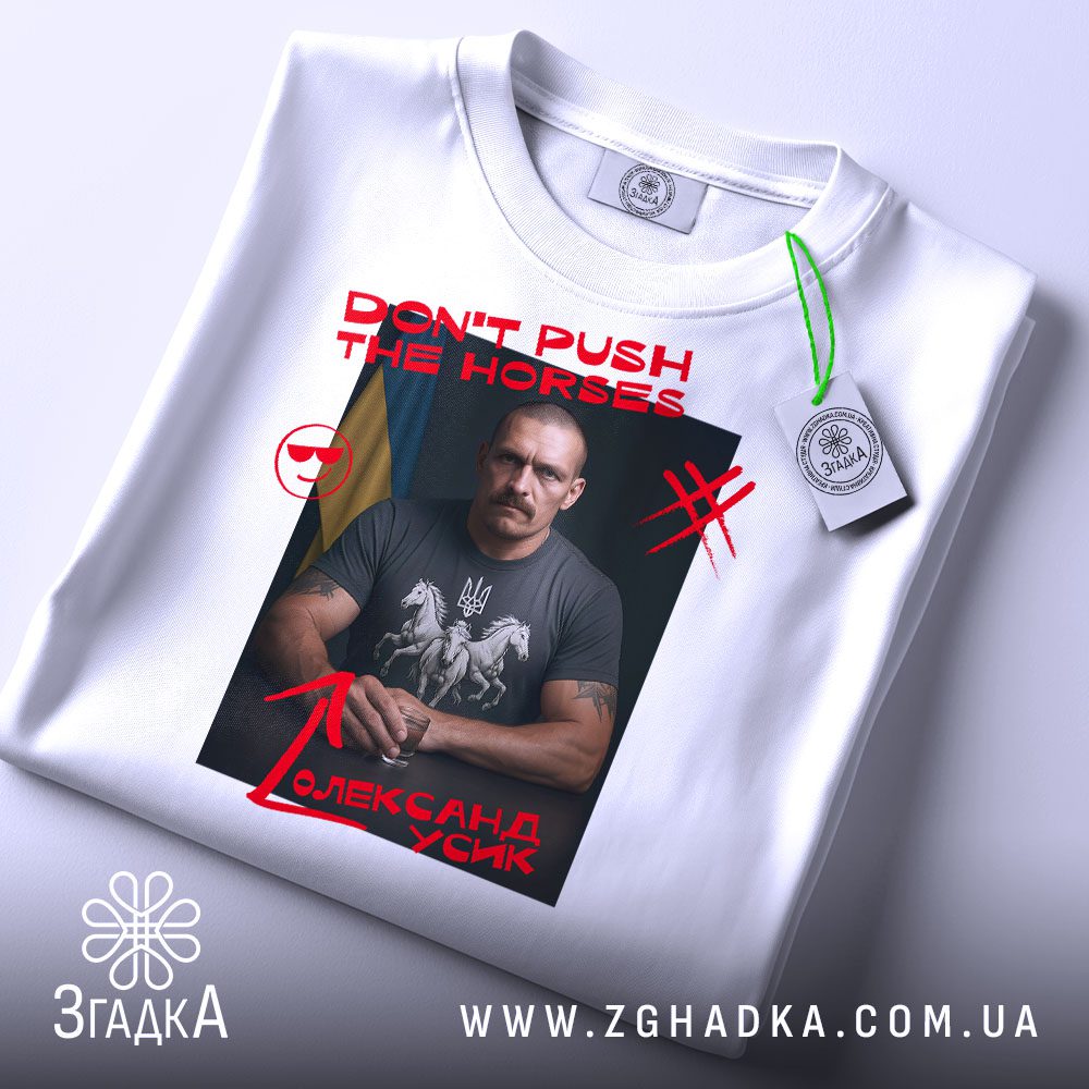 Складена біла футболка з принтом "don't push Усик" та етикеткою "Згадка".