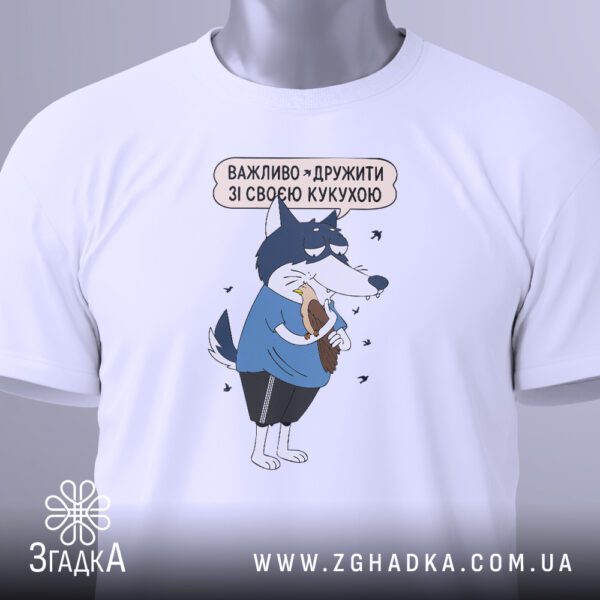 Крупний план чорного текстового принта "важливо дружити зі своєю кукухою" на білій футболці.