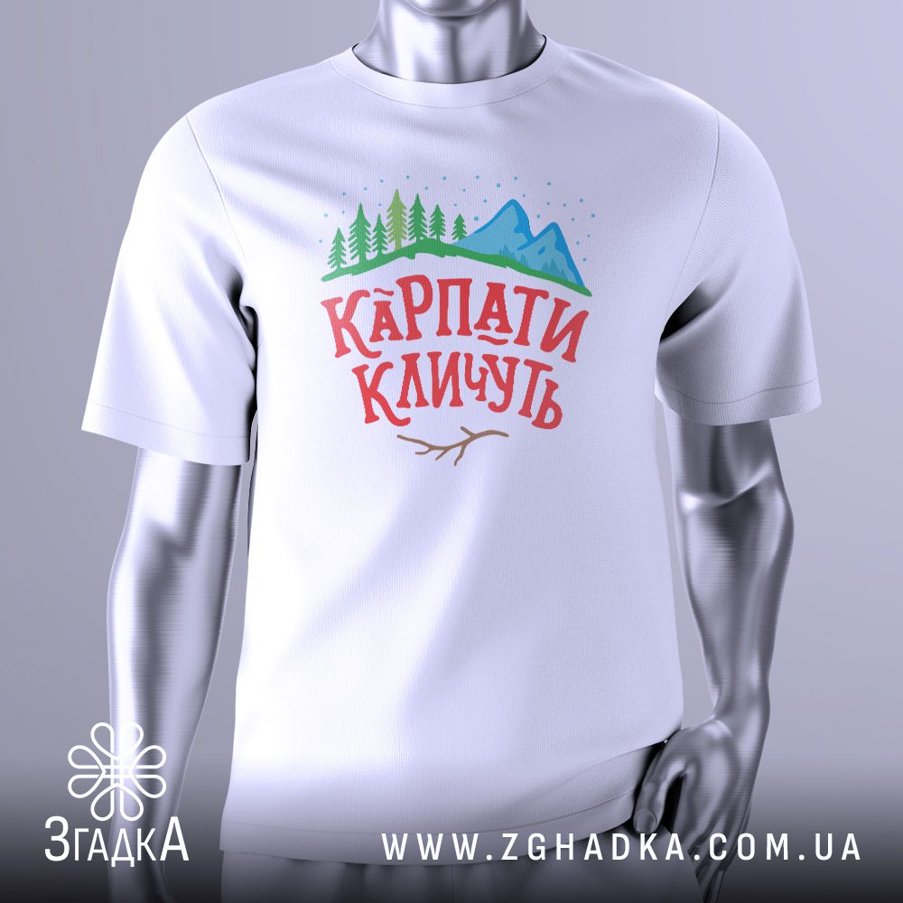 Біла футболка з кольоровим графічним принтом: стилізоване зображення Карпатських гір в синьо-фіолетових тонах з помаранчевим заходом сонця та написом "КАРПАТИ КЛИЧУТЬ". Футболка представлена на сірому манекені.