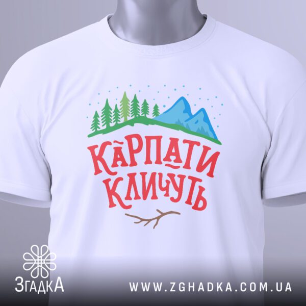 Крупний план кольорового графічного принта "КАРПАТИ КЛИЧУТЬ" на білій футболці: стилізовані гори, захід сонця та напис.