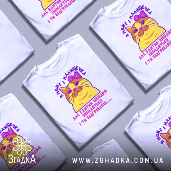 Кілька білих футболок з принтом "кішка з характером", складені стопкою або розкладені поруч на світлому фоні.