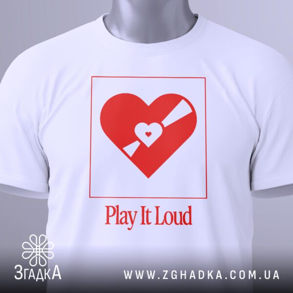 Крупний план принта "Play It Loud" з серцем та гучномовцем на білій футболці, що детально показує графіку та текст.