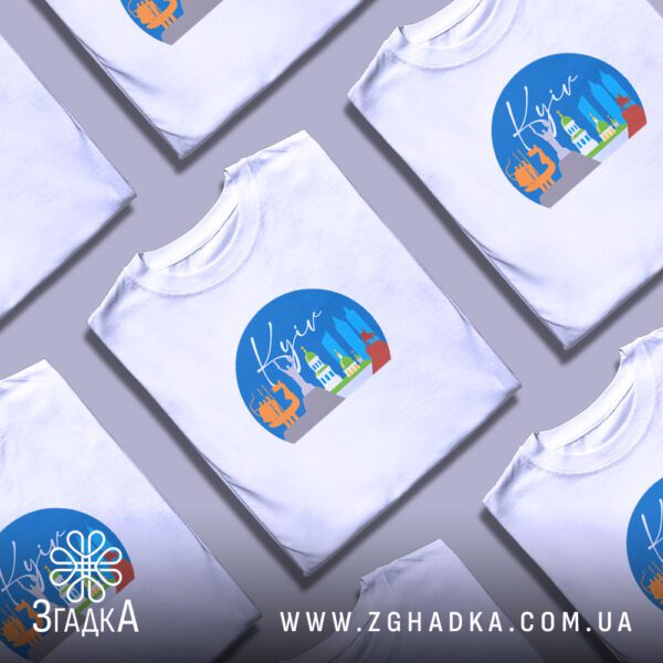 Кілька білих футболок з принтом "Київ видатні пам’ятки", складені стопкою або розкладені поруч на світлому фоні.