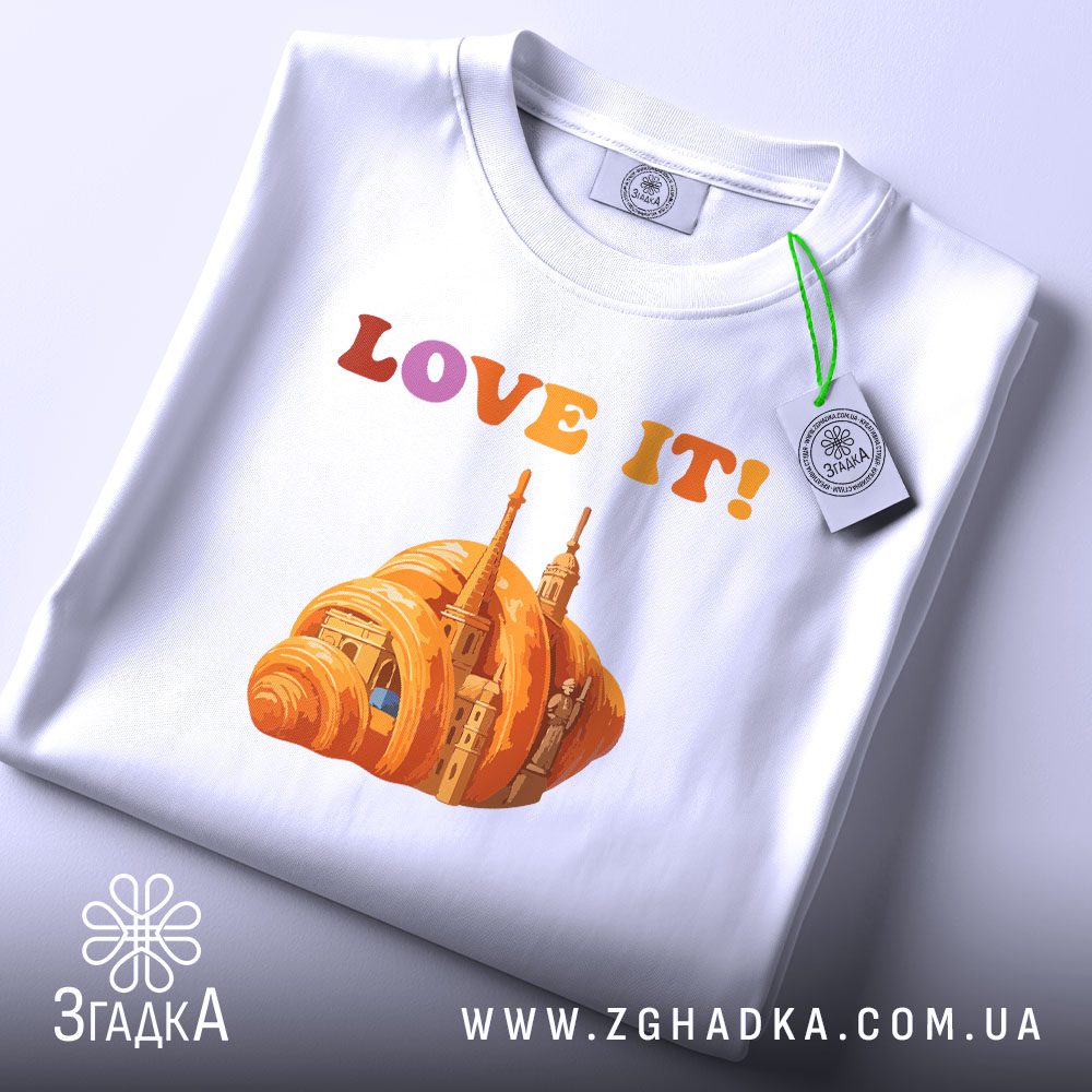 Складена біла футболка з принтом "love it круасан" та етикеткою "Згадка".