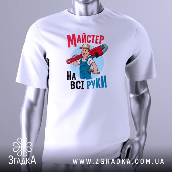 Біла футболка з чорним текстовим принтом "Майстер на всі руки". Напис виконаний стильним шрифтом. Футболка представлена на сірому манекені.