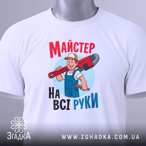 Крупний план чорного текстового принта "Майстер на всі руки" на білій футболці.