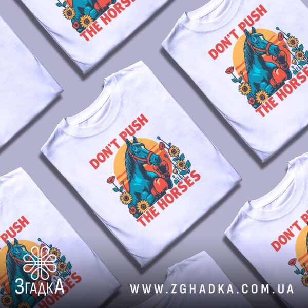 Кілька білих футболок з принтом "мемна фраза кінь", складені стопкою або розкладені поруч на світлому фоні.