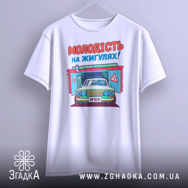 Біла футболка з принтом "молодість на жигулях", що висить на білих плічках, демонструючи дизайн.