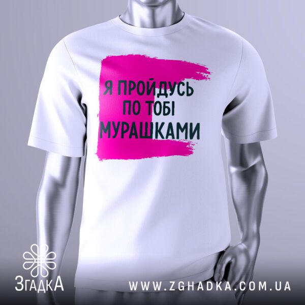 Біла футболка з графічним принтом у центрі. На принті зображені стилізовані червоно-рожеві мурашки або лінії, що створюють ефект "мурашок по шкірі", а поруч з ними напис "Я пройдусь по тобі мурашками". Фон принта яскраво-рожевий. Футболка на сірому манекені.