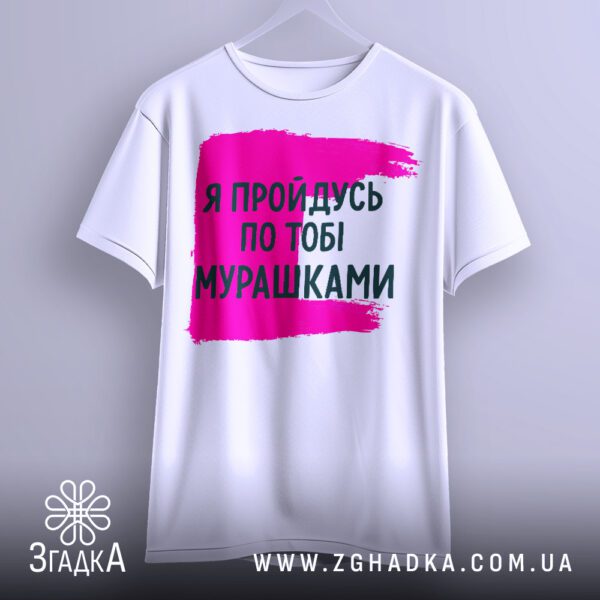 Біла футболка з принтом "мурашки по шкірі", що висить на білих плічках, демонструючи дизайн.