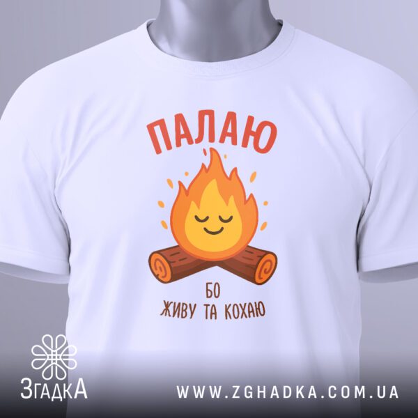 Крупний план білого текстового принта "Палаю бо живу та кохаю" з елементом вогню на чорній футболці.