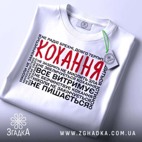 Складена біла футболка з принтом "про силу кохання" та етикеткою "Згадка".