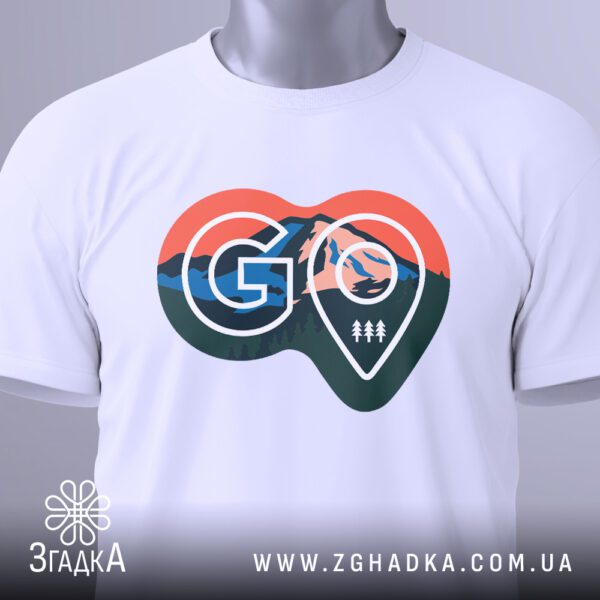 Крупний план принта "GO" у формі мапи з горами й деревами на білій футболці, що детально показує текстури та елементи.