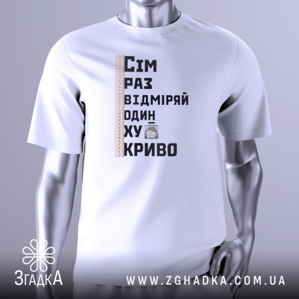 Біла футболка з чорно-білим графічним принтом у центрі. На принті зображена лінійка, над якою розміщено текст "СІМ РАЗ ВІДМІРЯЙ", а під нею "ОДИН — ХУЙ КРИВО". Дизайн має грубий, рукописний вигляд. Футболка на сірому манекені.