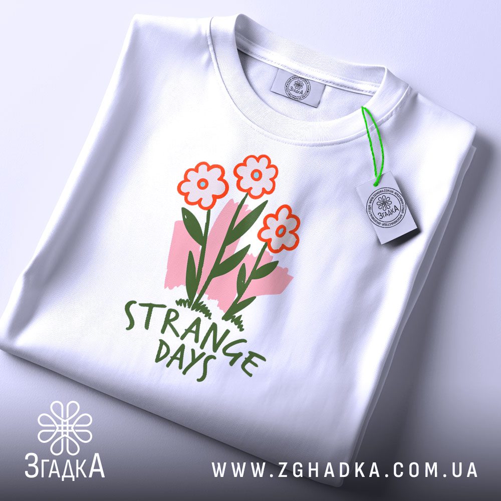 Складена біла футболка з принтом "strange days квіти" та етикеткою "Згадка".
