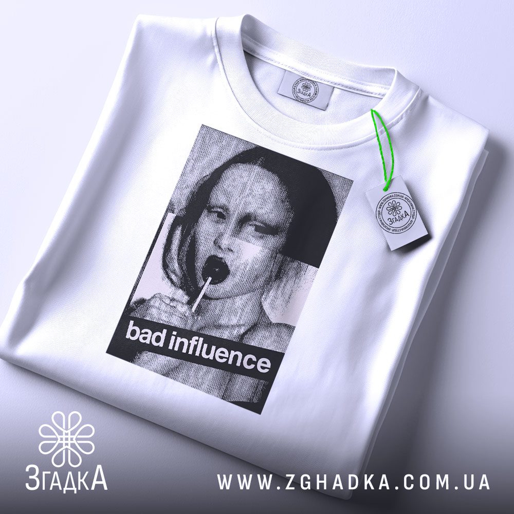 Складена біла футболка з принтом "bad influence" та етикеткою "Згадка".