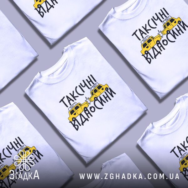 Кілька білих футболок з принтом "таксічні відносини жарт", складені стопкою або розкладені поруч на світлому фоні.