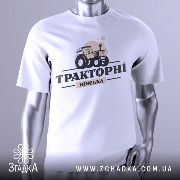 Біла футболка Тракторні Війська на сріблястому манекені, що демонструє гумористичний принт трактора, який тягне танк.