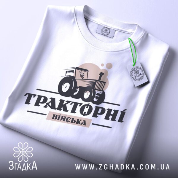 Складена біла футболка Тракторні Війська з яскравим принтом та етикеткою згадка.