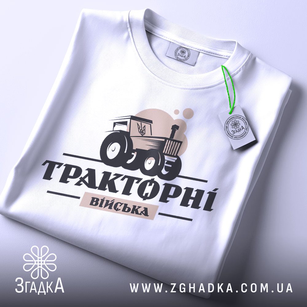 Складена біла футболка Тракторні Війська з яскравим принтом та етикеткою згадка.
