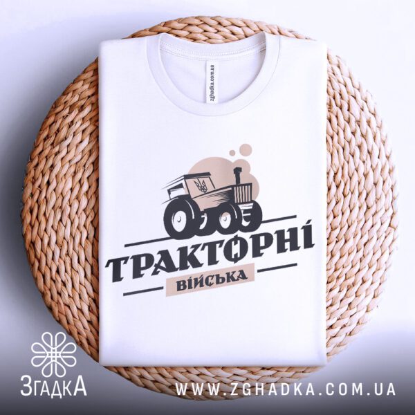 Фронтальний вигляд білої футболки Тракторні Війська на манекені, крупний план принта.