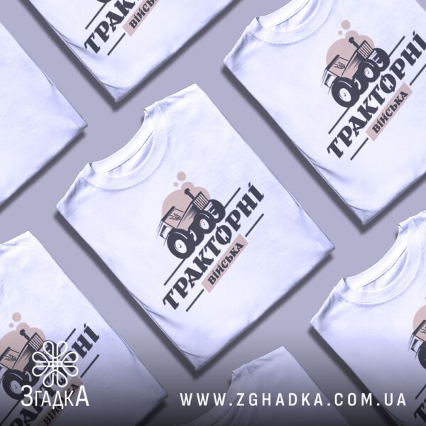 Креативна презентація складених білих футболок Тракторні Війська з повторюваним принтом.