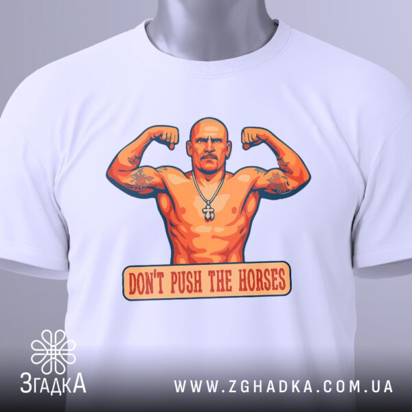 Крупний план принта "Don’t push the horses" на білій футболці, що детально показує зображення мускулистого боксера та текст.