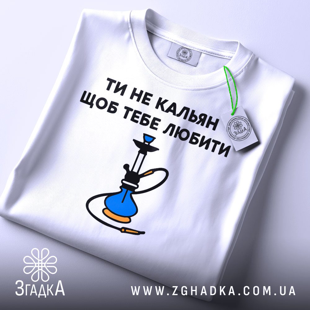 Складена біла футболка з принтом "ти не кальян" та етикеткою "Згадка".