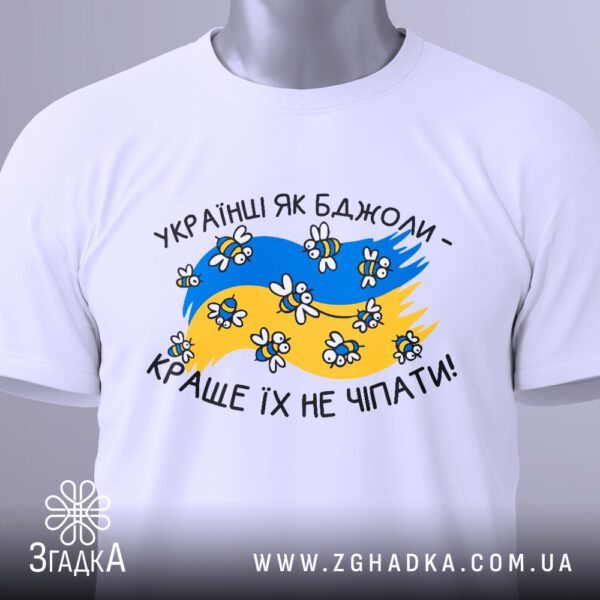 Крупний план принта "Українці як бджоли" на білій футболці, що детально показує бджілок, прапор та напис.