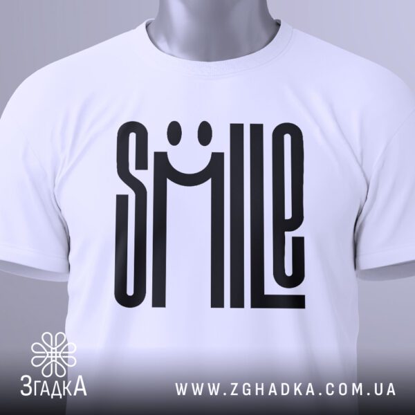 Крупний план принта "SMILE" на білій футболці, що детально показує стилізоване усміхнене обличчя.