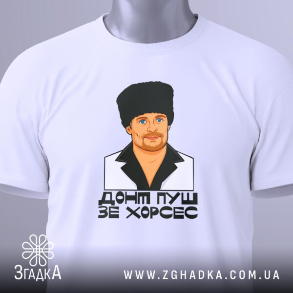 Крупний план принта "ДОНТ ПУШ ЗЕ ХОРСЕС" на білій футболці, що детально показує зображення чоловіка в кожусі та текст.