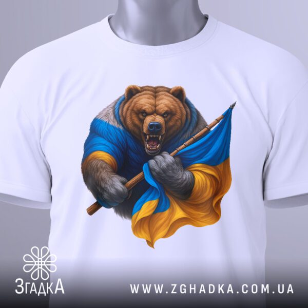 Крупний план принта "ведмідь з прапором" на білій футболці, що детально показує обличчя ведмедя, прапор та спис.